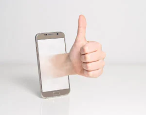 Thumbs up hand coming out of a mobile phone